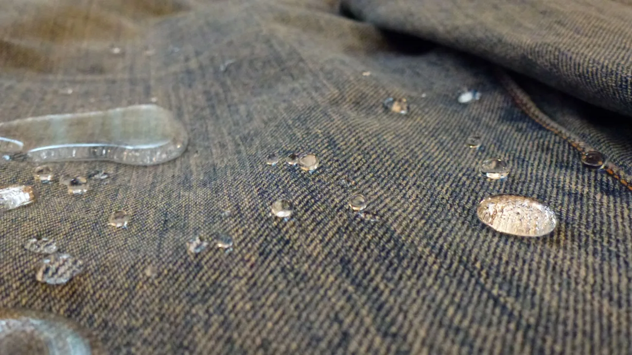 Water droplets beading on treated denim